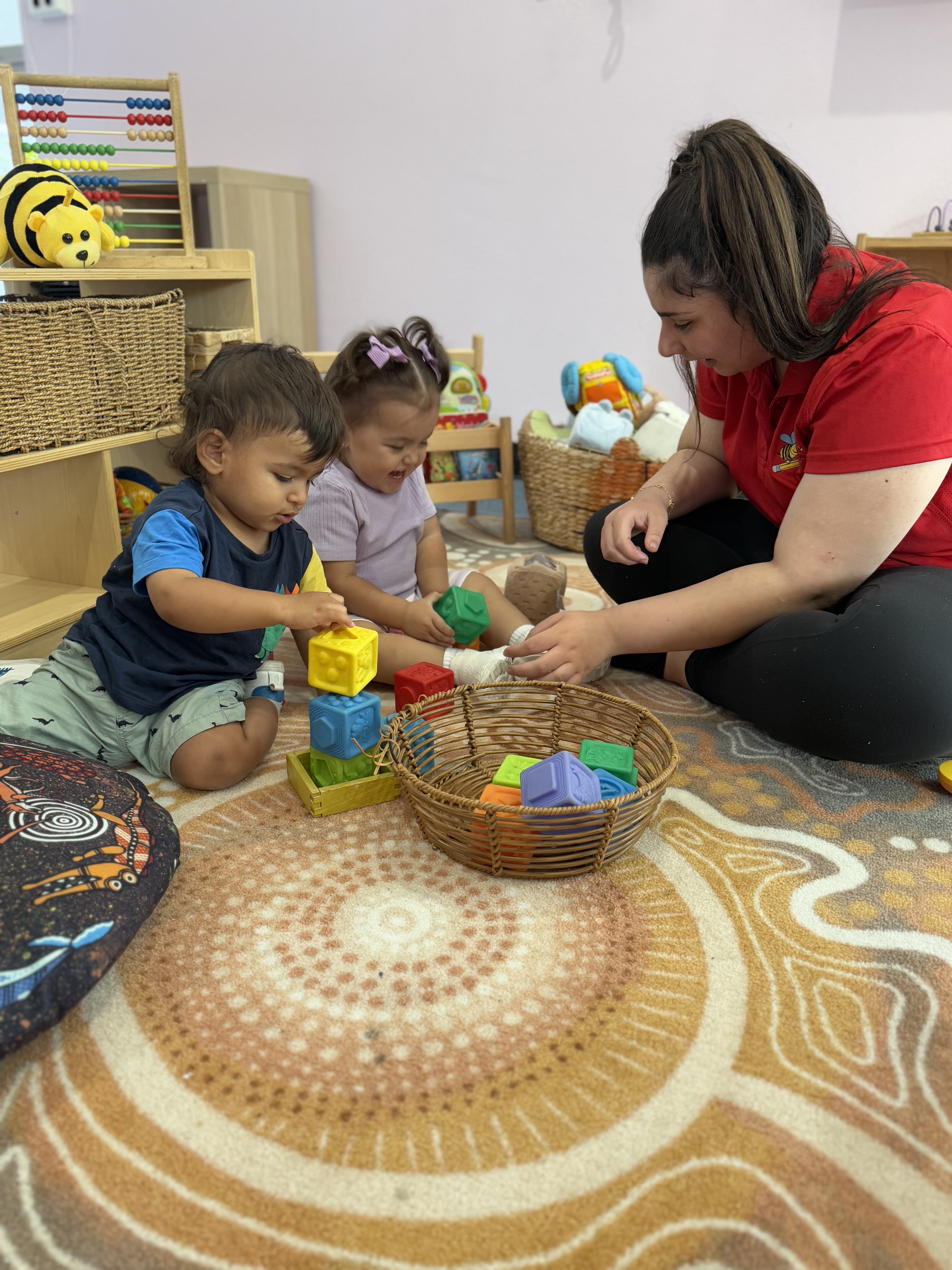 Educator helping the child put blocks on top of each other